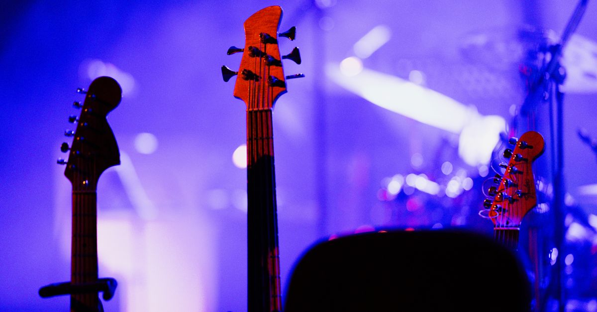 Electric guitars on stage under colorful concert lights, capturing the vibrant music atmosphere.